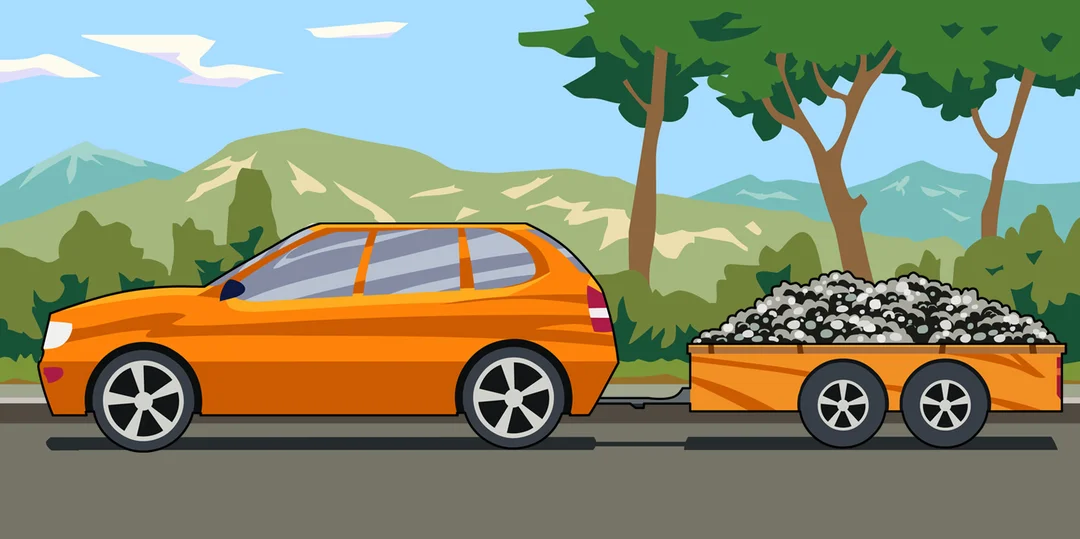 Oranje auto trekt een geladen aanhangwagen